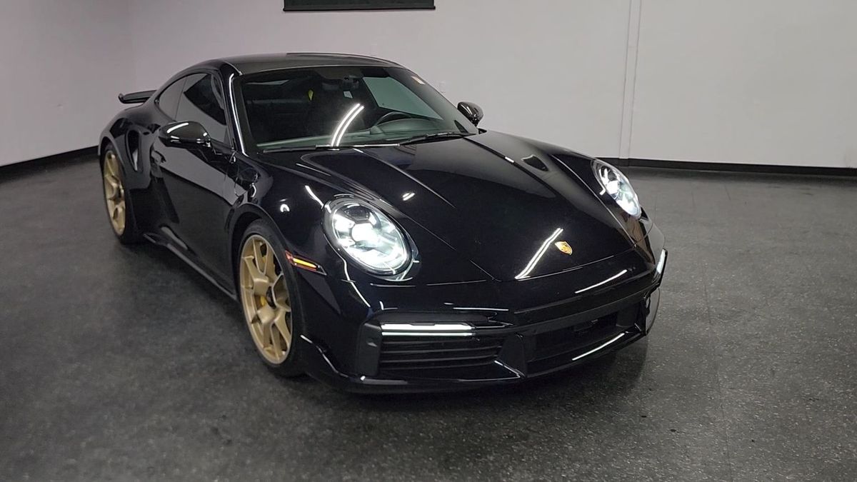 A black Porsche 911 in the Iconic Coach showroom